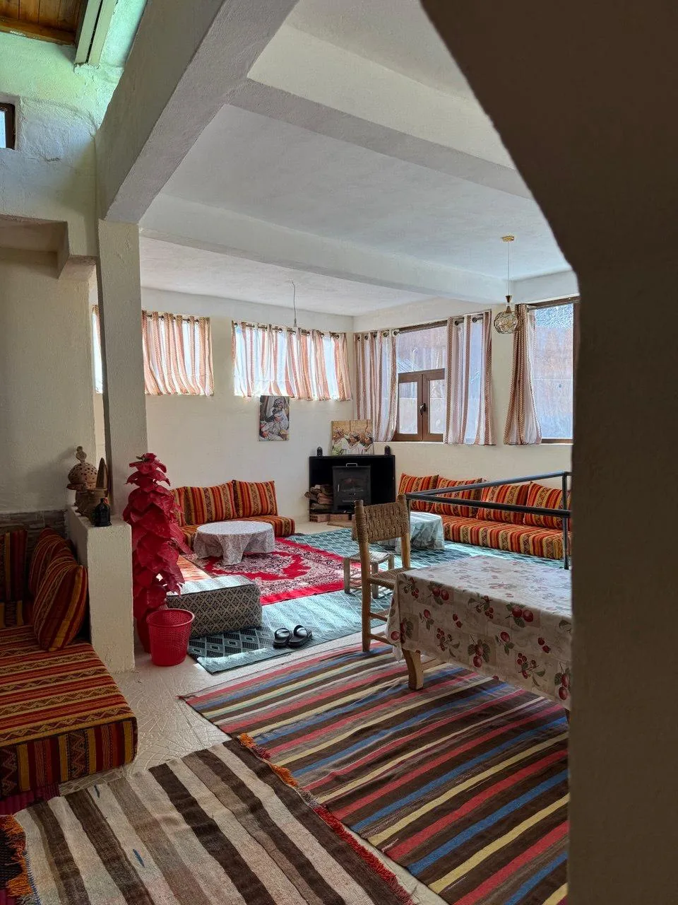 Traditional Berber salon with a wood stove and striped floor seating