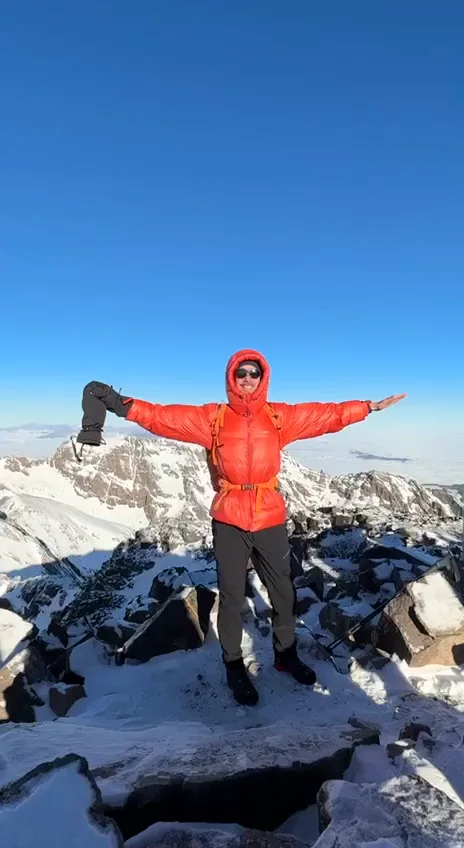 Video: a trekker celebrating on the snow-covered summit of Mount Toubkal